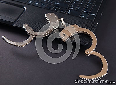 Police metal handcuffs and computer keyboard Stock Photo