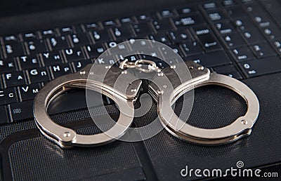Police metal handcuffs and computer keyboard Stock Photo