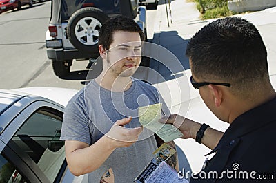 Police Officer Holding Out Ticket Stock Photo