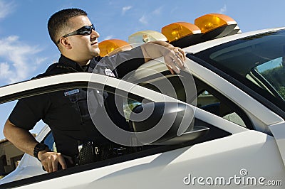 Police Officer Leaning On Patrol Car Stock Photo