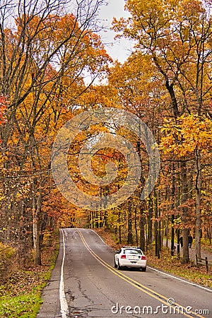 Police Officer patrols the main road of a local park in Fall. Editorial Stock Photo