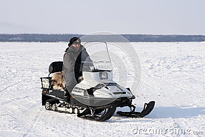 Police officer on a snowmobile among the tundra in winter in Siberia Editorial Stock Photo
