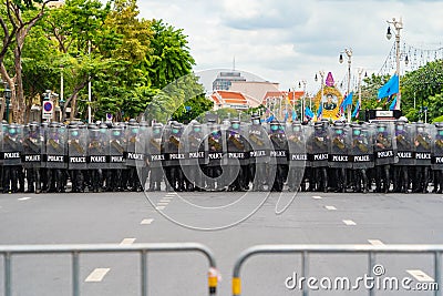 Police officer team with weapons and riot shield protection. Violence Against Demonstrators and protesters with barrier fence. Stock Photo