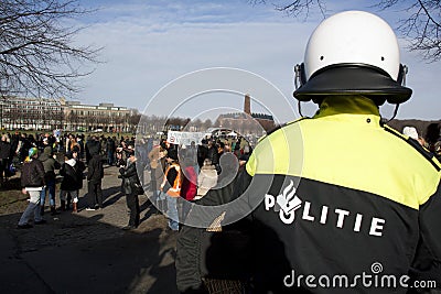 Police officer watching protesters Editorial Stock Photo