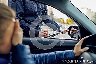 Police officer writes out a protocol to driver Stock Photo