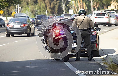 Police officer writing a traffic ticket to a motorist Editorial Stock Photo