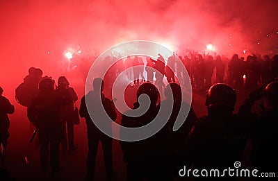 Police looking at football fans with torches Stock Photo