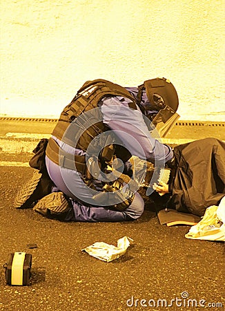 Police tactical unit member assisting a victim Editorial Stock Photo