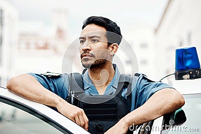 Police, thinking and man officer by a car for an investigation or patrol for law protection in city or urban town Stock Photo