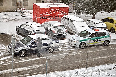 Police traffic partol stop a car. Policeman stand outside vehicle in bad weather and talk with driver while snow falls. Editorial Stock Photo