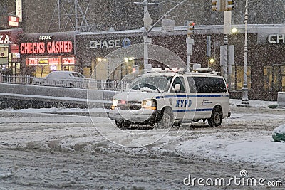 Police vehicle crosses intersection of Bronx New York street during snow storm Editorial Stock Photo
