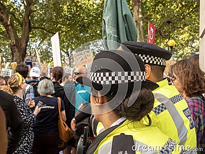 A police woman observes protesters marching at the climate strikes in London Editorial Stock Photo