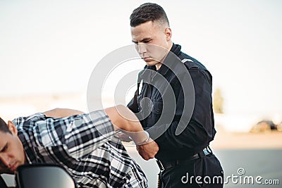 Policeman arrests the car thief on road Stock Photo