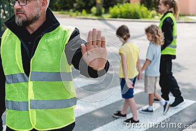 Policeman in a reflective vest raises his hand to stop the car Stock Photo