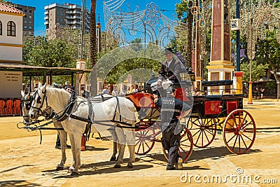 A policeman talking to a coachman of a pair of light gray horses at the Horse Feria, Jerez de la Frontera, Andalusia, Spain, May 1 Editorial Stock Photo