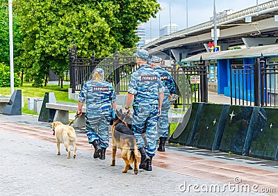 Policemen and dogs patrol the park near the Exhibition of Achievements of the National Economy. Cynologists at VDNKh. Editorial Stock Photo