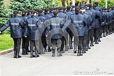 The policemen in uniform with the inscription Police in Ukrainian, goes along the street in Dnipro city Ukraine Editorial Stock Photo