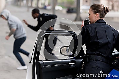 policewoman talking by radio set while her partner Stock Photo