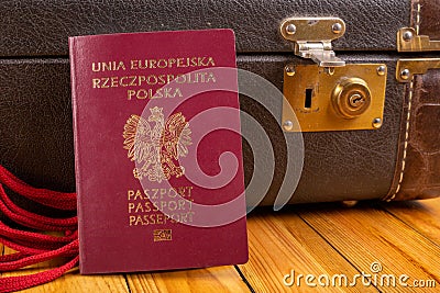 Polish passport and travel suitcase on a wooden table. Accessories for the traveler before the international trip Stock Photo