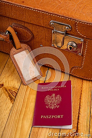 Polish passport and travel suitcase on a wooden table. Accessories for the traveler before the international trip Stock Photo