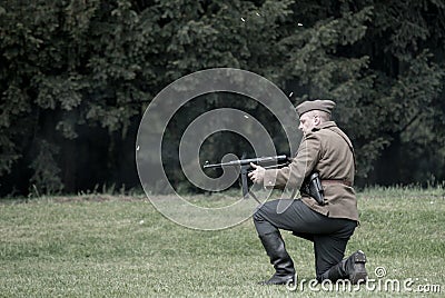 Polish soldier firing burst from Thompson machine gun during historical reenactment of WWII Editorial Stock Photo