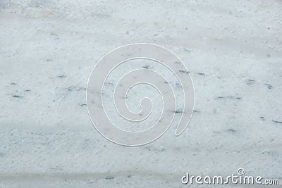 A polished slab of white marble with gray blurry stripes and dots called Nestos Beige Stock Photo