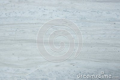 A polished slab of white marble with stripes and dots called Nestos Beige Stock Photo