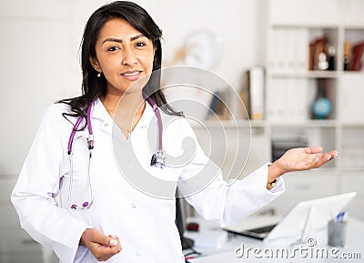 Female doctor politely inviting patient to medical office Stock Photo