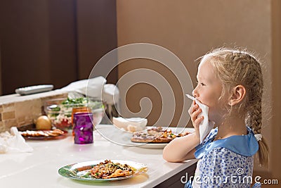 Polite little girl eating homemade pizza Stock Photo
