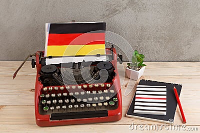 Political, news and education concept - red typewriter, flag of the Germany and notebooks Stock Photo