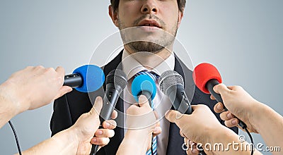 Politician is talking ang giving interview to reporters. Many microphones recording him. Stock Photo