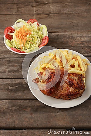 Peruvian food called Pollo a la brasa with salad and french fries Stock Photo
