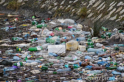 Water polution. Plastic and other residues thrown into the water. A large amount of trash polluting our waters. The Impact of Editorial Stock Photo