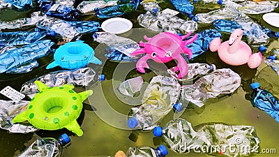 Pollution of the environment. plastic bottles in water and inflatable toys Stock Photo