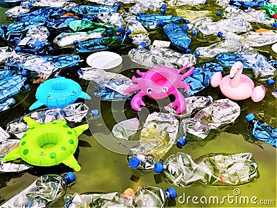 Pollution of the environment. plastic bottles in water and inflatable toys Stock Photo