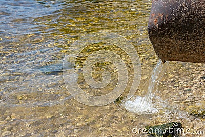 Discharge of toxic or contaminated water into a river or lake. Stock Photo