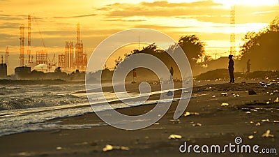Pollution industry concept , Beach pollution. Plastic bottles and other trash on sea beach and Factory pipe polluting air against Stock Photo