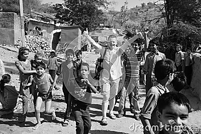 India: Polish photo reporter in the slums of Vijaynagar surrounded by children Editorial Stock Photo