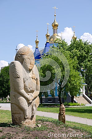 Polovtsian stone sculpture in the background of the Orthodox Church Editorial Stock Photo