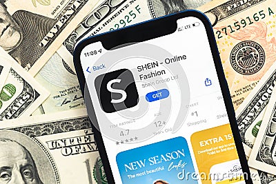 Shein fashion shopping app logo on mobile phone screen. Business background with dollar money banknotes photo Editorial Stock Photo