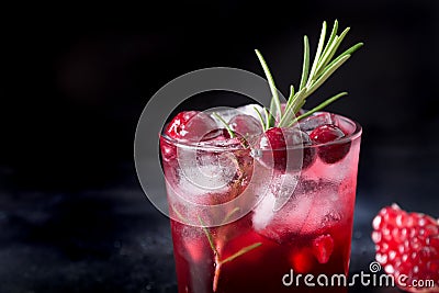 Pomegranate Christmas cocktail with rosemary, sparkling wine, club soda on black. Close up Stock Photo