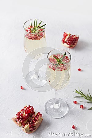 Pomegranate Christmas cocktail with rosemary, sparkling wine on white table. Xmas Holiday drink Stock Photo