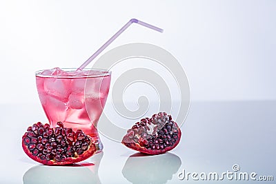 Pomegranate pieces and fresh glass of juice with straw. Stock Photo