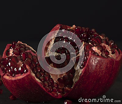 pomegranate fruit. cut tropical red fruit on a black . pomegranate seeds Stock Photo