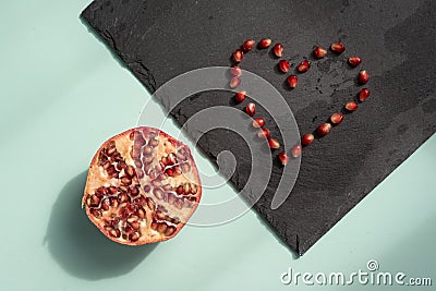 Pomegranate heart of seeds on green desk flat lay Stock Photo