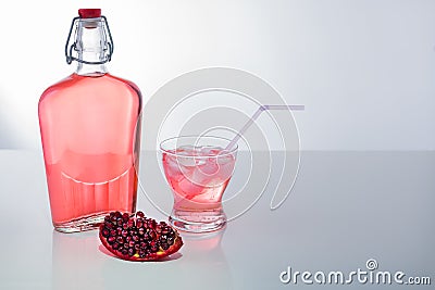 Pomegranate Juice in a glass with ice and Straw and a full bottle. Stock Photo