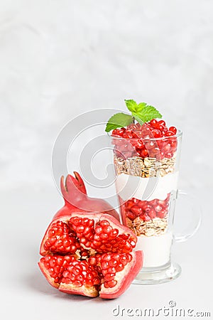 Pomegranate parfait - sweet organic layered dessert with granola flakes, yogurt and ripe fruit seeds. Stock Photo