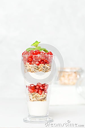 Pomegranate parfait - sweet organic layered dessert with granola flakes, yogurt and ripe fruit seeds. Stock Photo