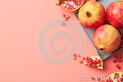 Pomegranates on a grey tray on pastel pink background Stock Photo