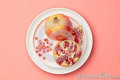 Pomegranates on a grey tray on pastel pink background Stock Photo